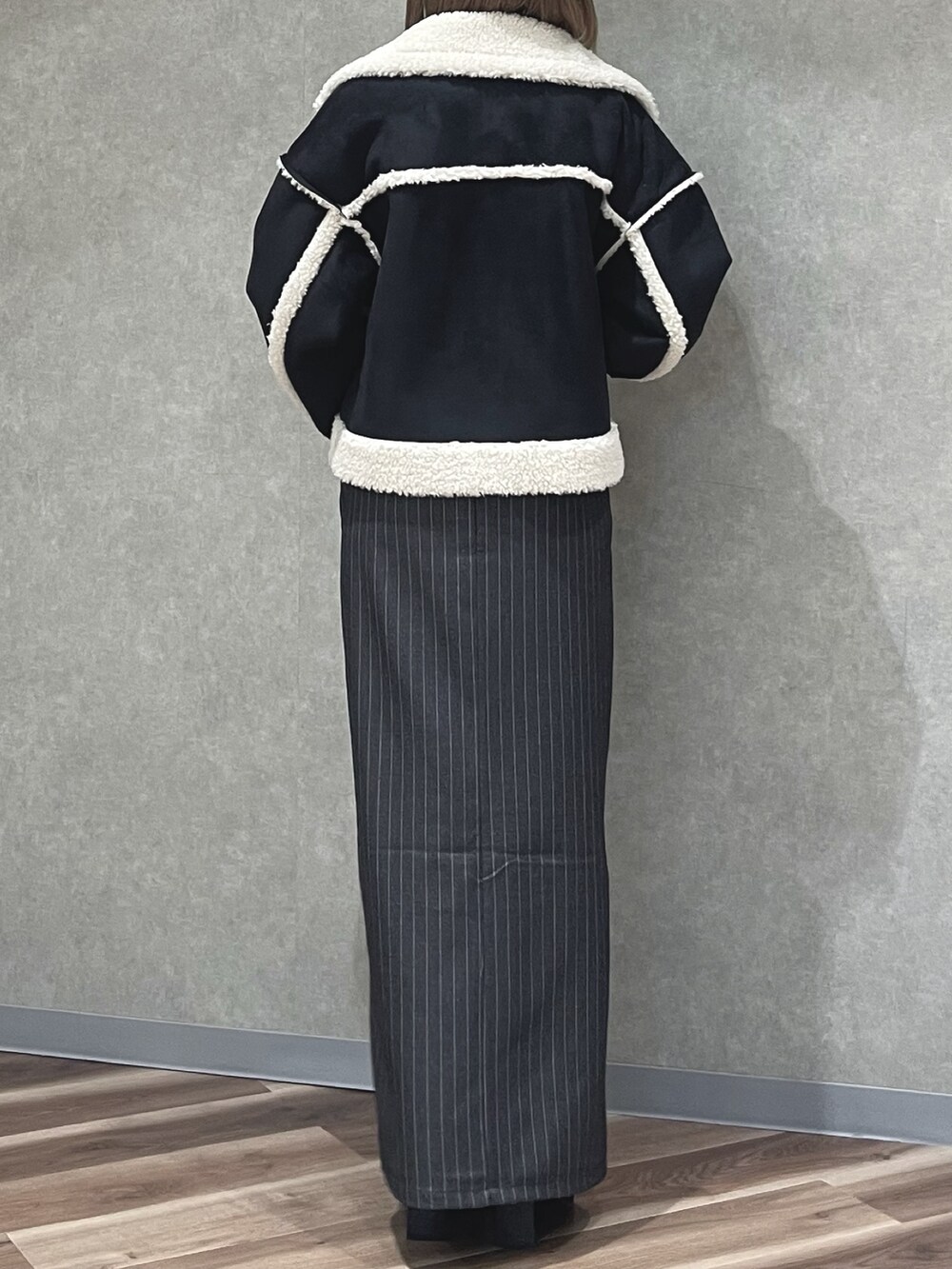 ホワイト系のニット/セーター、グレー系のスカート、ブラック系のブーツを着用したレディースの冬コーディネートの3枚目の写真