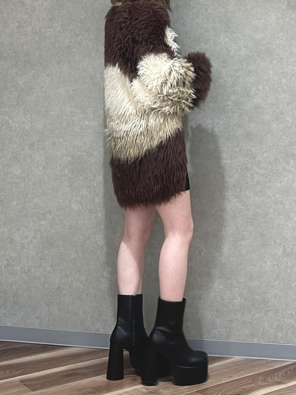 ベージュ系のワンピース、その他のカーディガン/ボレロ、ブラック系のブーツを着用したレディースの秋コーディネートの2枚目の写真