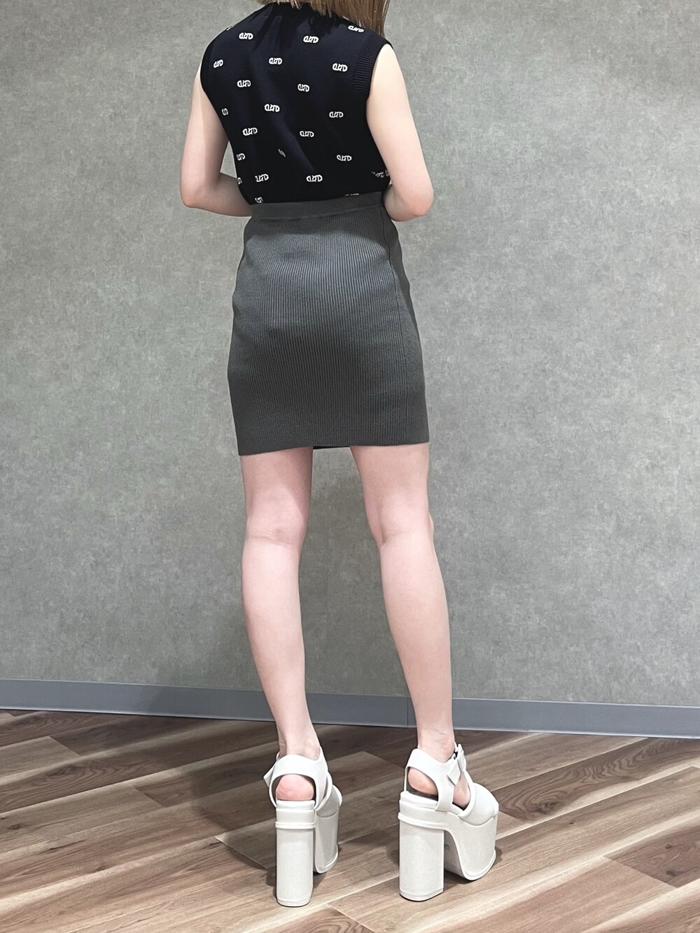 ブラック系のニット/セーター、グレー系のスカート、その他のハンドバッグを着用したレディースの春コーディネートの2枚目の写真