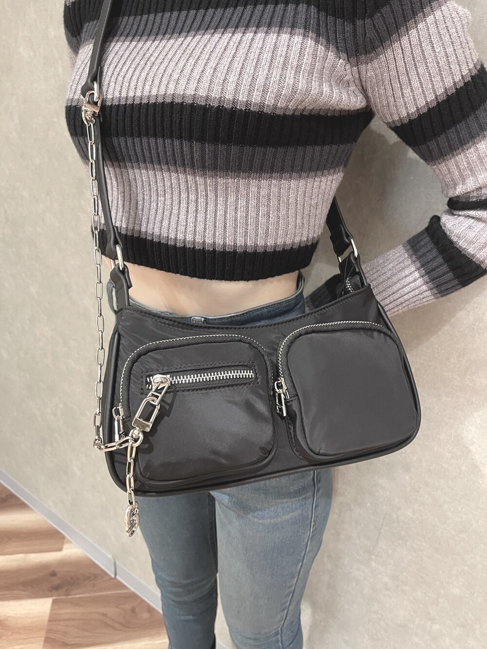 その他のニット/セーター、グリーン系のハンドバッグ、ブルー系のデニムパンツを着用したレディースの秋コーディネートの5枚目の写真