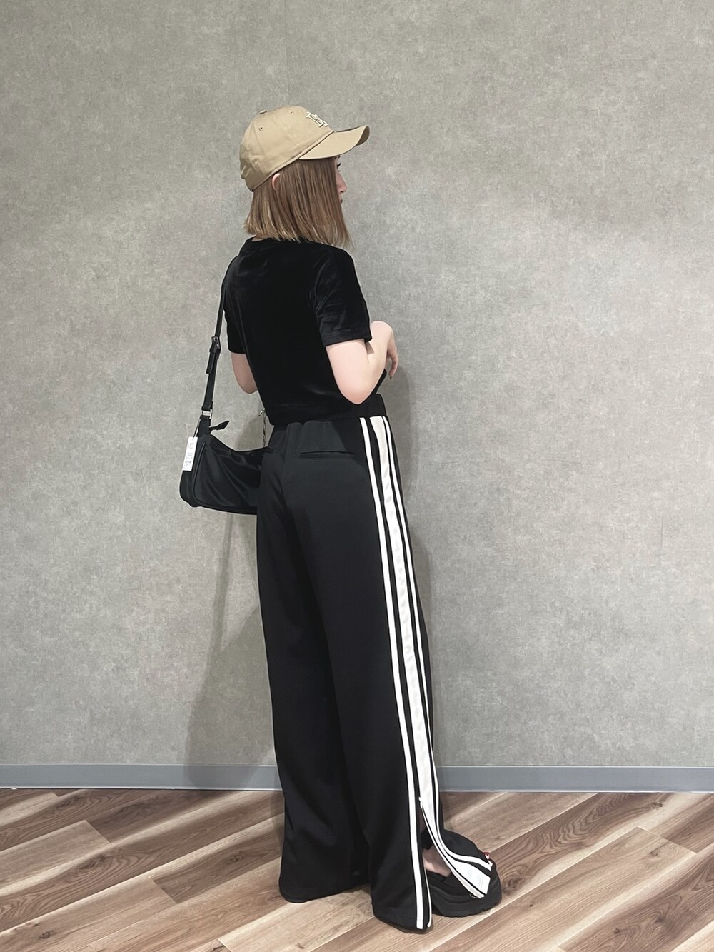 オレンジ系のTシャツ/カットソー、ブラック系のその他パンツ、グレー系のサンダルを着用したレディースの夏コーディネートの2枚目の写真