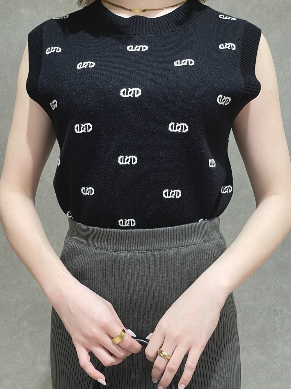 ブラック系のニット/セーター、グレー系のスカート、その他のハンドバッグを着用したレディースの春コーディネートの3枚目の写真