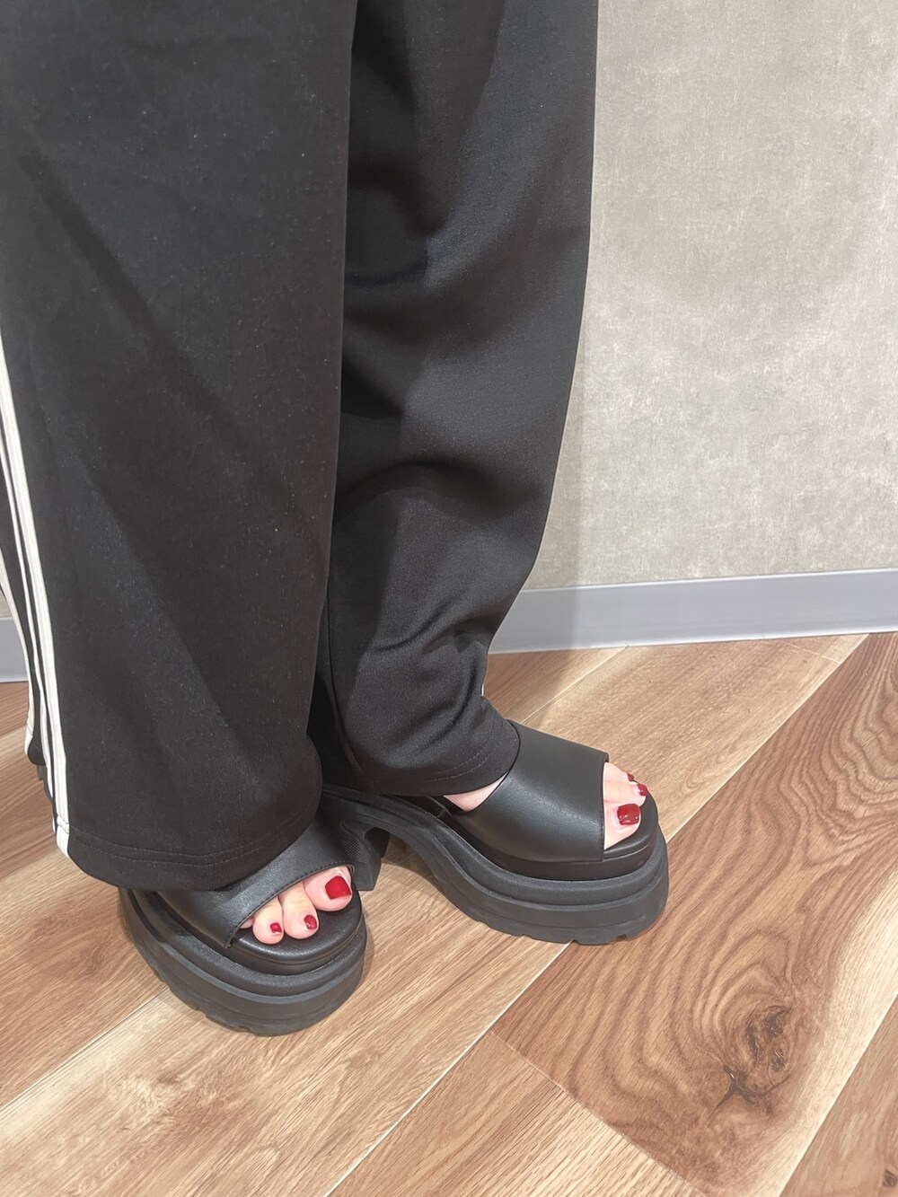 オレンジ系のTシャツ/カットソー、ブラック系のその他パンツ、グレー系のサンダルを着用したレディースの夏コーディネートの8枚目の写真