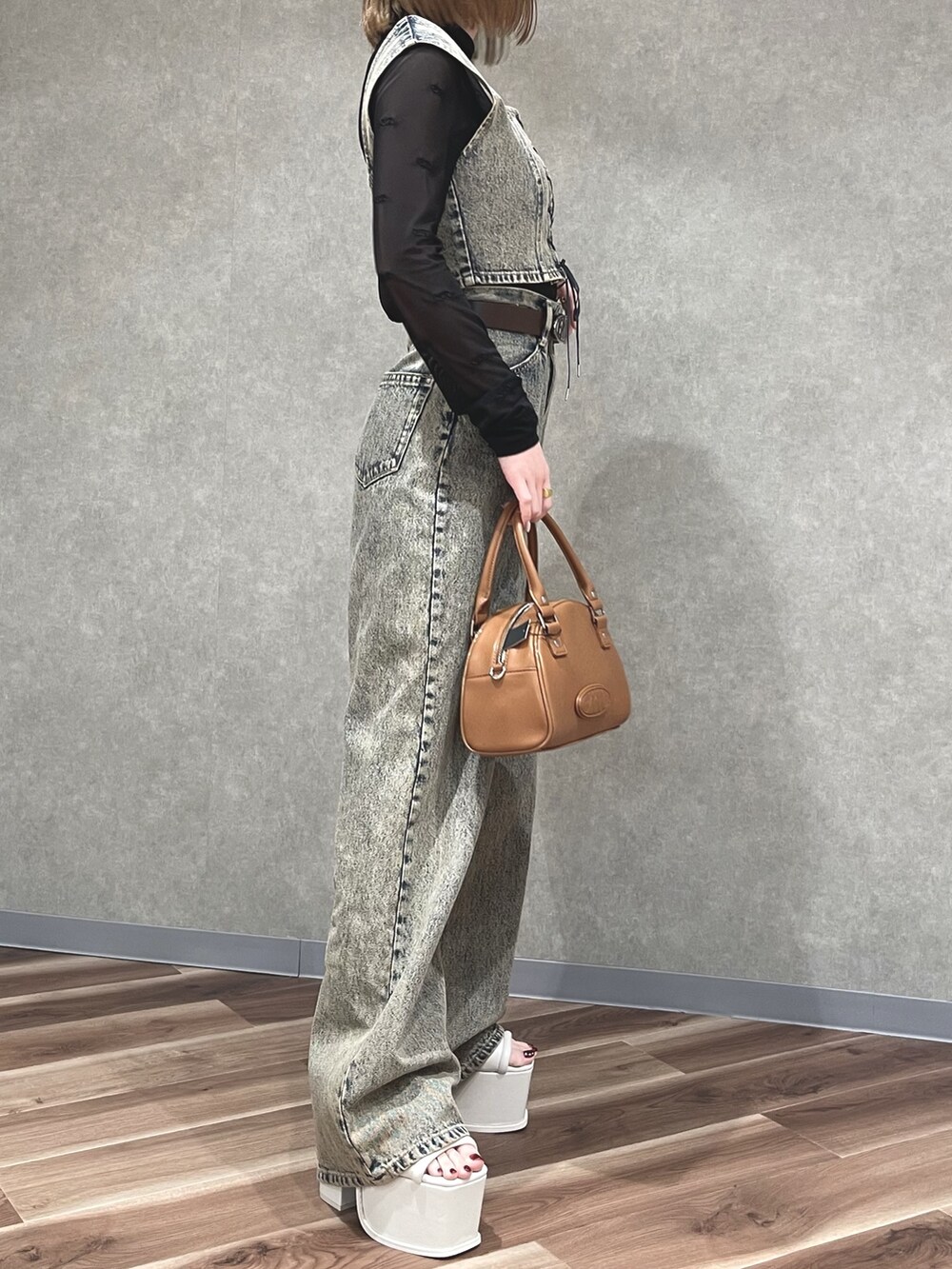 ベージュ系のその他トップス、ベージュ系のデニムパンツ、ブラウン系のハンドバッグを着用したレディースの春コーディネートの2枚目の写真