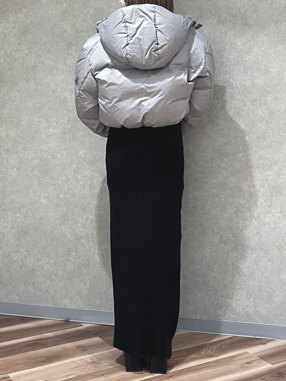 グレー系のダウンジャケット/コート、ホワイト系のハンドバッグ、ブルー系のワンピースを着用したレディースの冬コーディネートの3枚目の写真