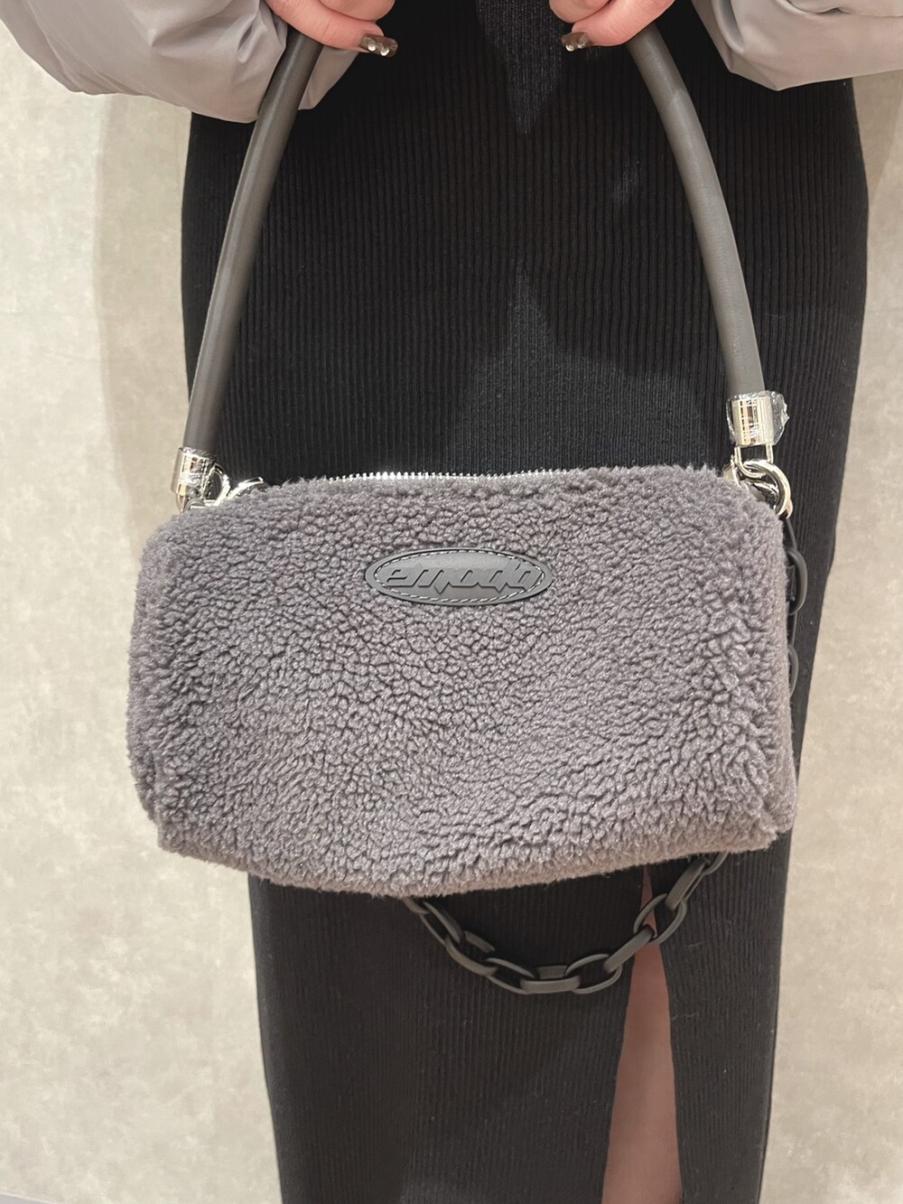 グレー系のダウンジャケット/コート、ホワイト系のハンドバッグ、ブルー系のワンピースを着用したレディースの冬コーディネートの5枚目の写真