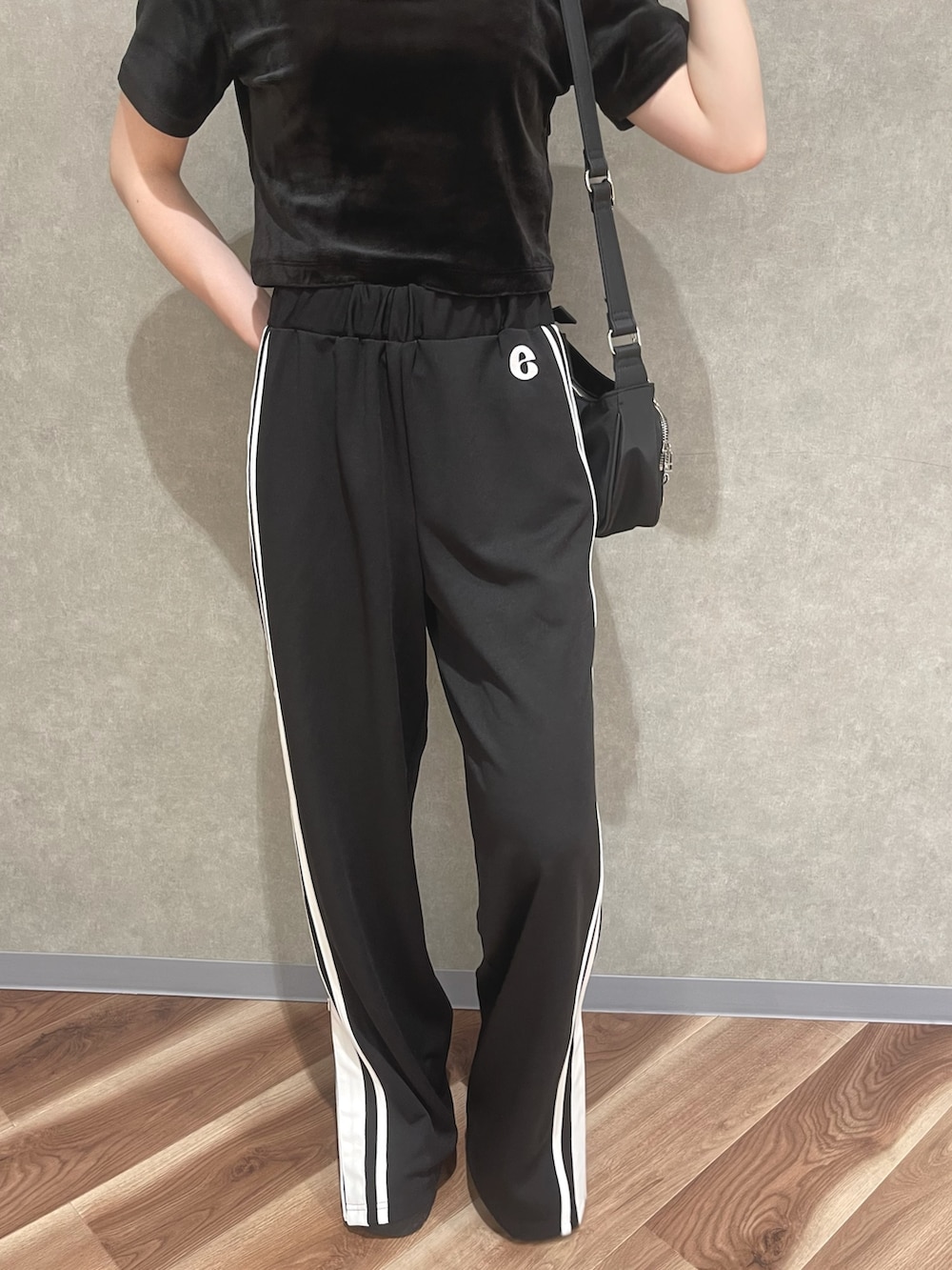 オレンジ系のTシャツ/カットソー、ブラック系のその他パンツ、グレー系のサンダルを着用したレディースの夏コーディネートの6枚目の写真