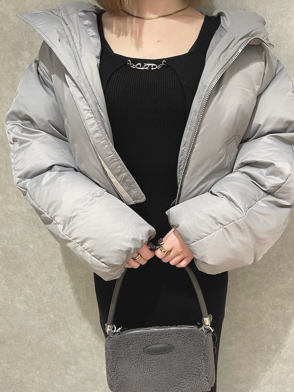 グレー系のダウンジャケット/コート、ホワイト系のハンドバッグ、ブルー系のワンピースを着用したレディースの冬コーディネートの4枚目の写真