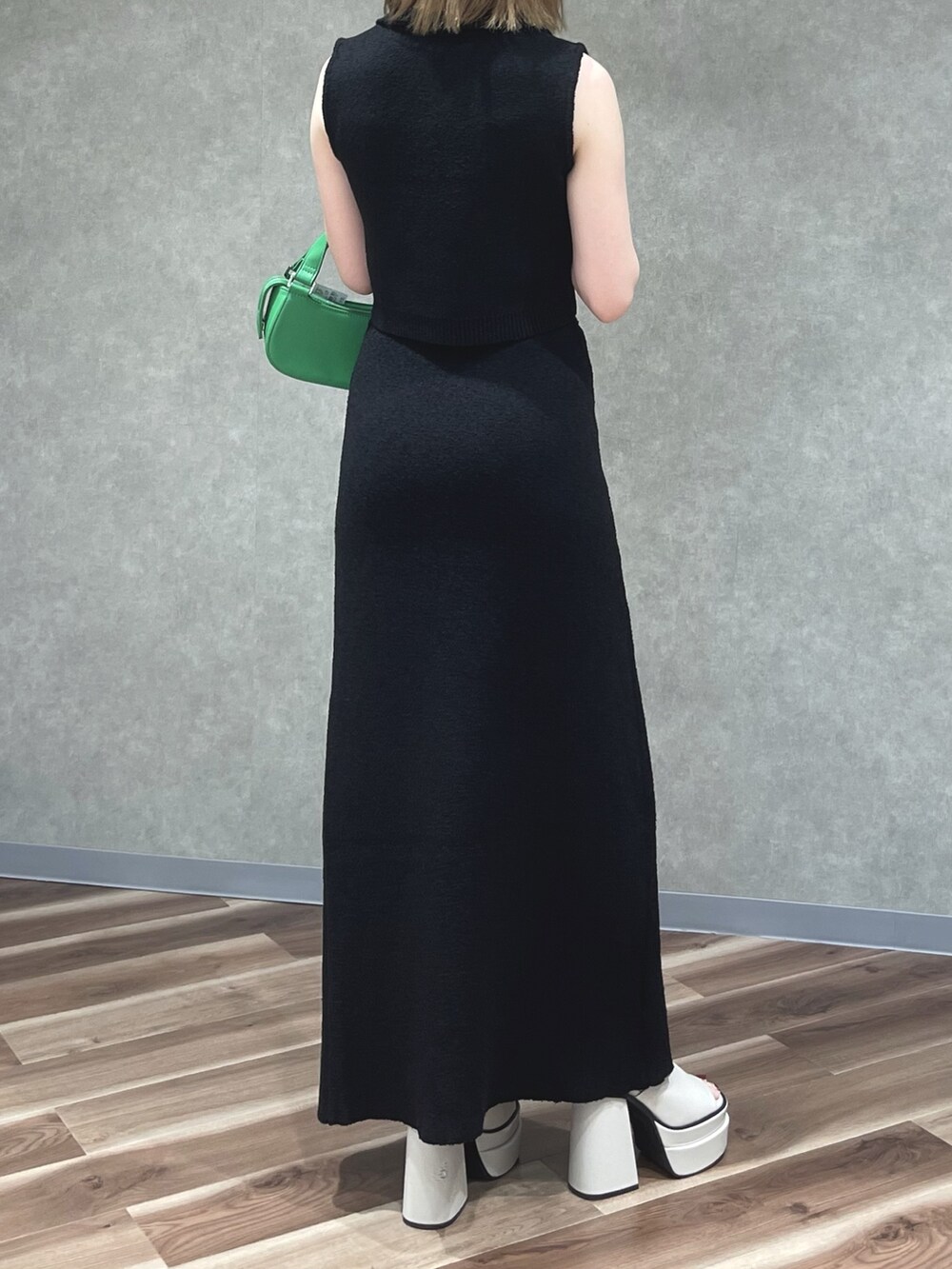 ブラック系のタンクトップ、ブラック系のスカート、グリーン系のハンドバッグを着用したレディースの夏コーディネートの3枚目の写真