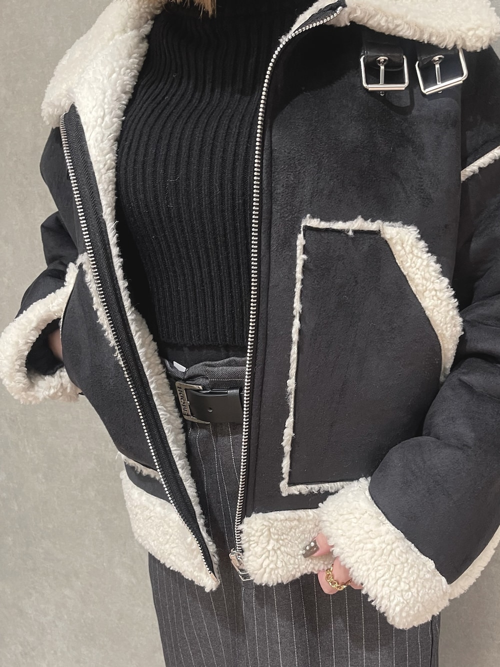 ホワイト系のニット/セーター、グレー系のスカート、ブラック系のブーツを着用したレディースの冬コーディネートの4枚目の写真