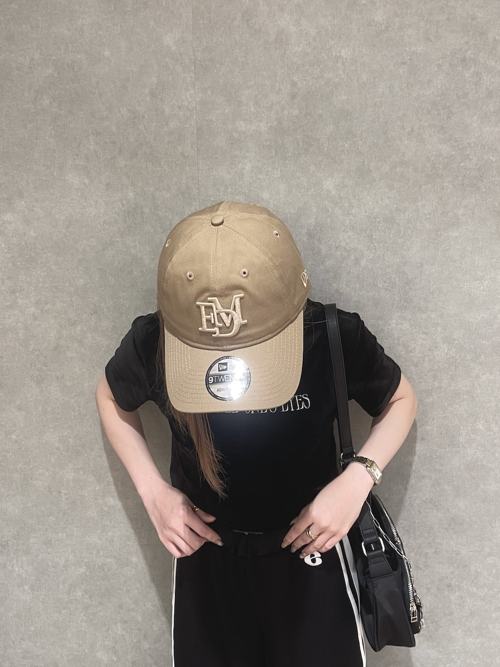 オレンジ系のTシャツ/カットソー、ブラック系のその他パンツ、グレー系のサンダルを着用したレディースの夏コーディネートの4枚目の写真