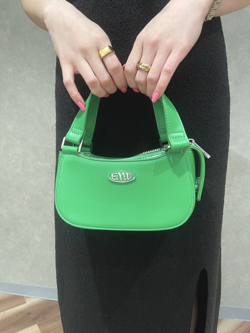 ブラック系のタンクトップ、ブラック系のスカート、グリーン系のハンドバッグを着用したレディースの夏コーディネートの5枚目の写真