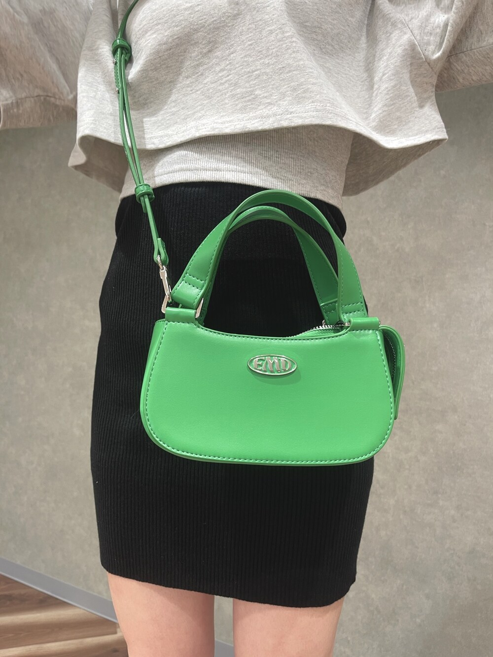 グレー系のTシャツ/カットソー、グリーン系のハンドバッグ、ブラック系のスカートを着用したレディースの春コーディネートの5枚目の写真