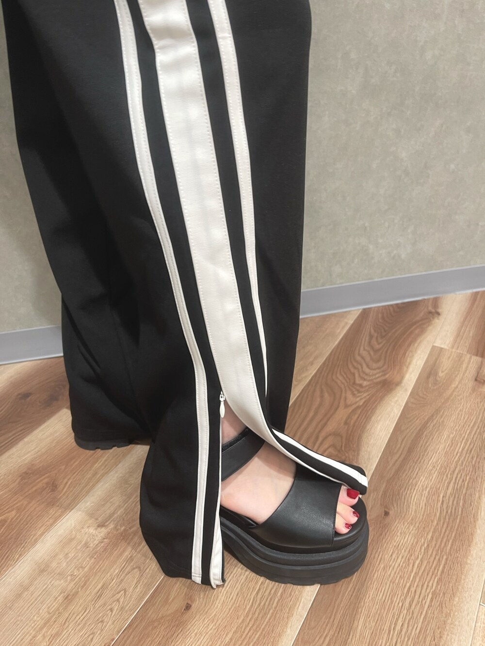 オレンジ系のTシャツ/カットソー、ブラック系のその他パンツ、グレー系のサンダルを着用したレディースの夏コーディネートの7枚目の写真