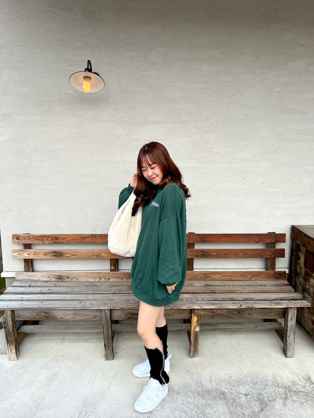 グリーン系のスウェット、ベージュ系のトートバッグ、ブラック系のその他パンツを着用したレディースの秋コーディネートの2枚目の写真