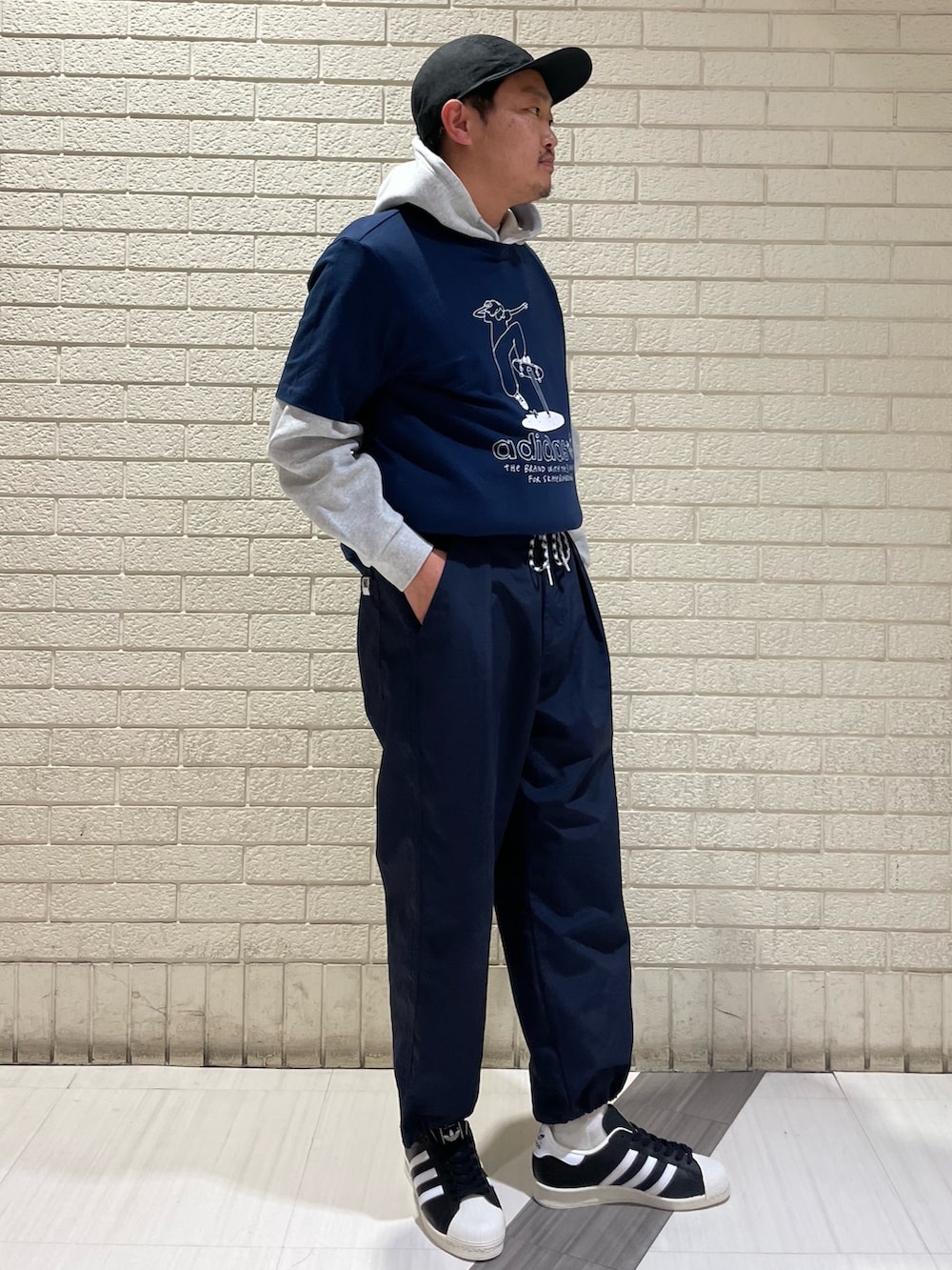 グレー系のスウェット、ブルー系のTシャツ/カットソー、ブラック系のスニーカーを着用したメンズの春コーディネートの3枚目の写真