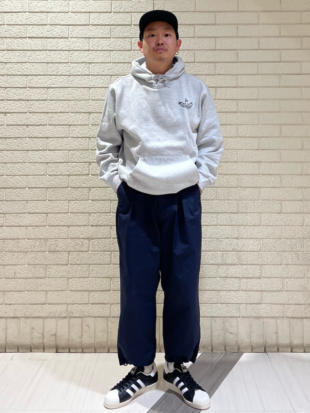 グレー系のスウェット、ブルー系のTシャツ/カットソー、ブラック系のスニーカーを着用したメンズの春コーディネートの2枚目の写真