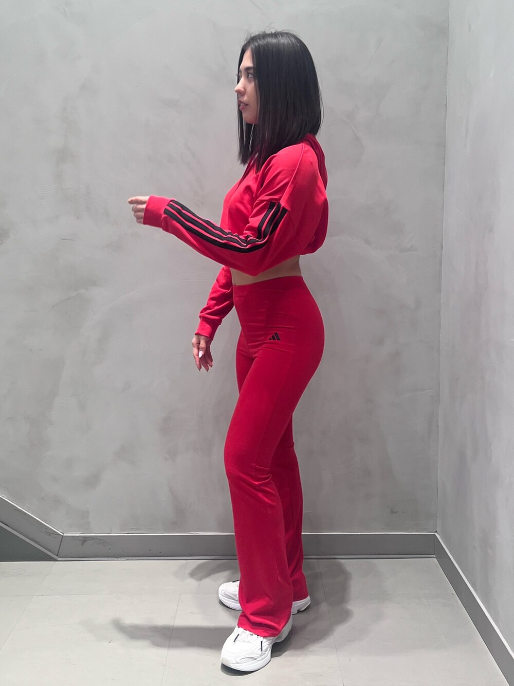 ホワイト系のスニーカー、レッド系のパーカーを着用したレディースの冬コーディネートの2枚目の写真