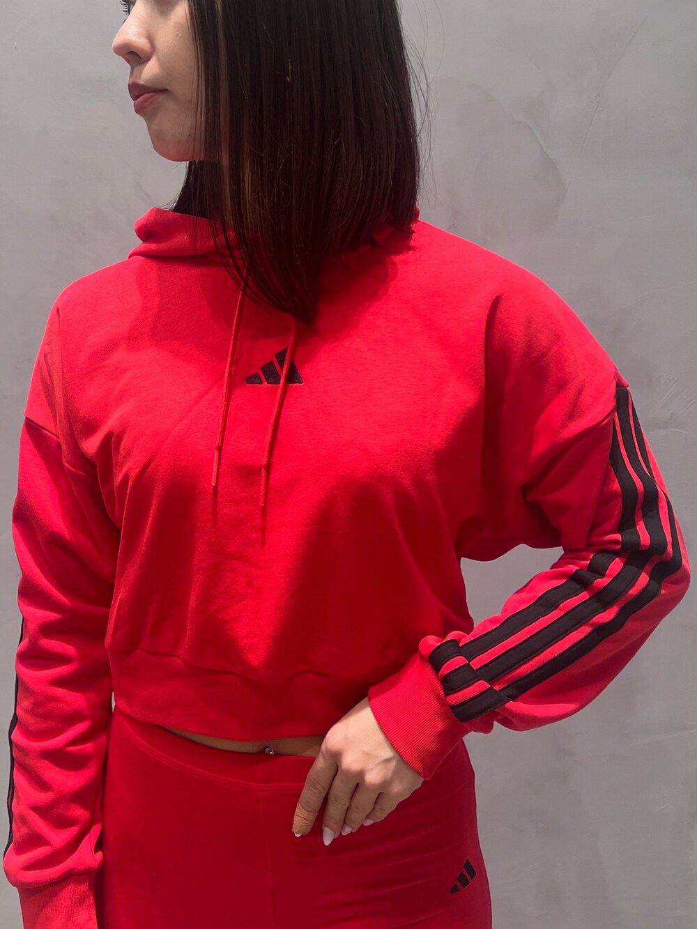 ホワイト系のスニーカー、レッド系のパーカーを着用したレディースの冬コーディネートの5枚目の写真