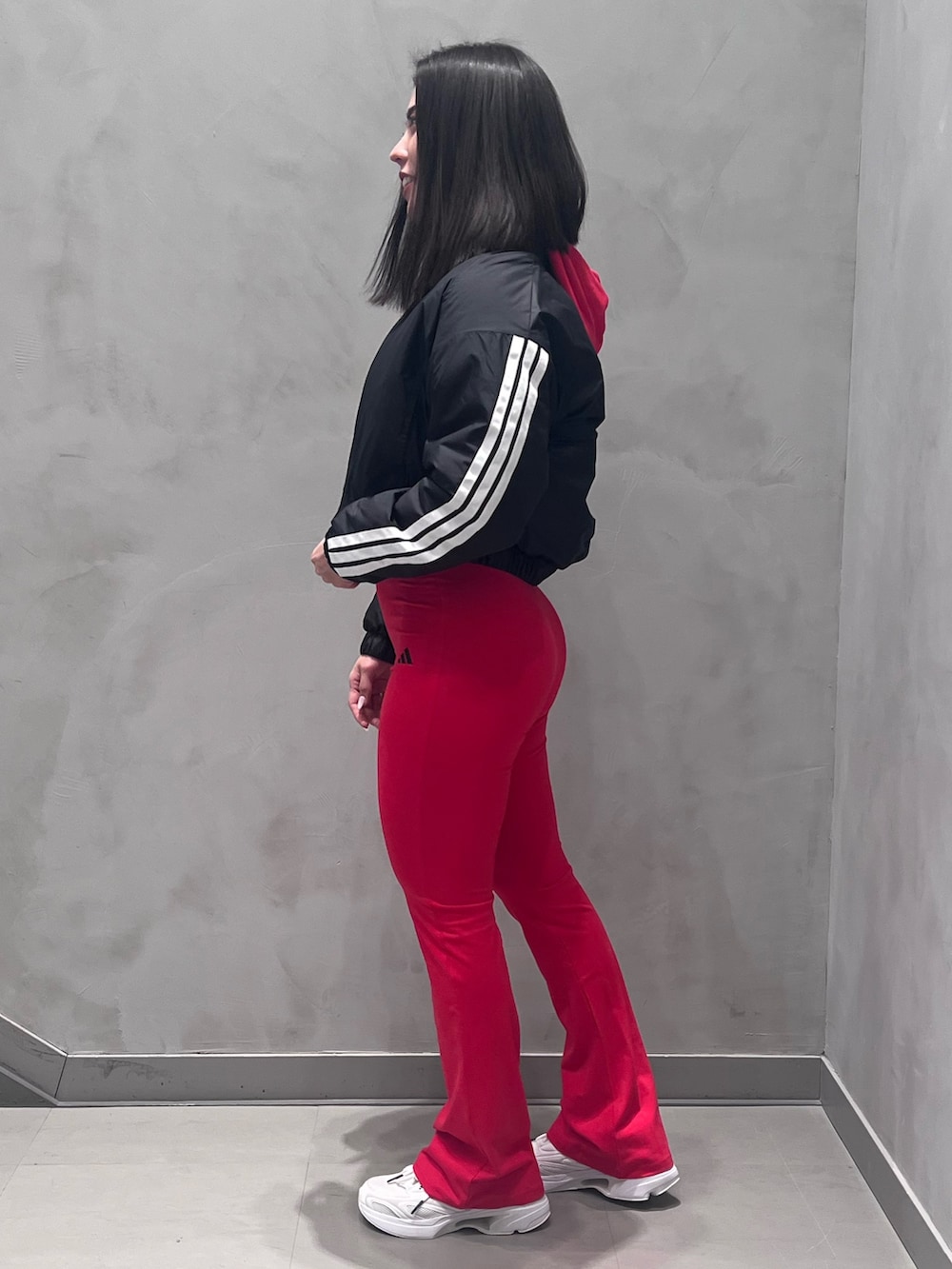 ホワイト系のスニーカー、レッド系のパーカーを着用したレディースの冬コーディネートの3枚目の写真