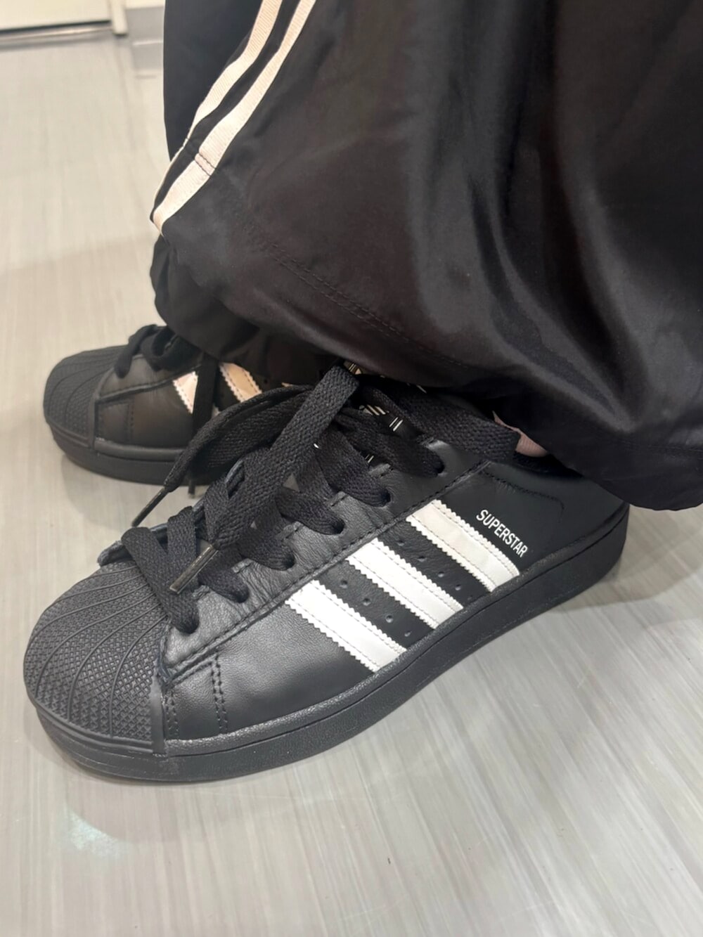 ブラック系のスウェットパンツ、ブラック系のスニーカーを着用したレディースの夏コーディネートの4枚目の写真