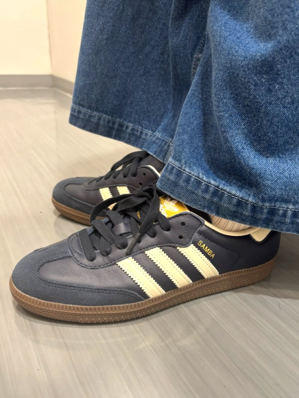 レッド系のトップス、ブルー系のデニムパンツ、ブルー系のスニーカーを着用したレディースの夏コーディネートの4枚目の写真