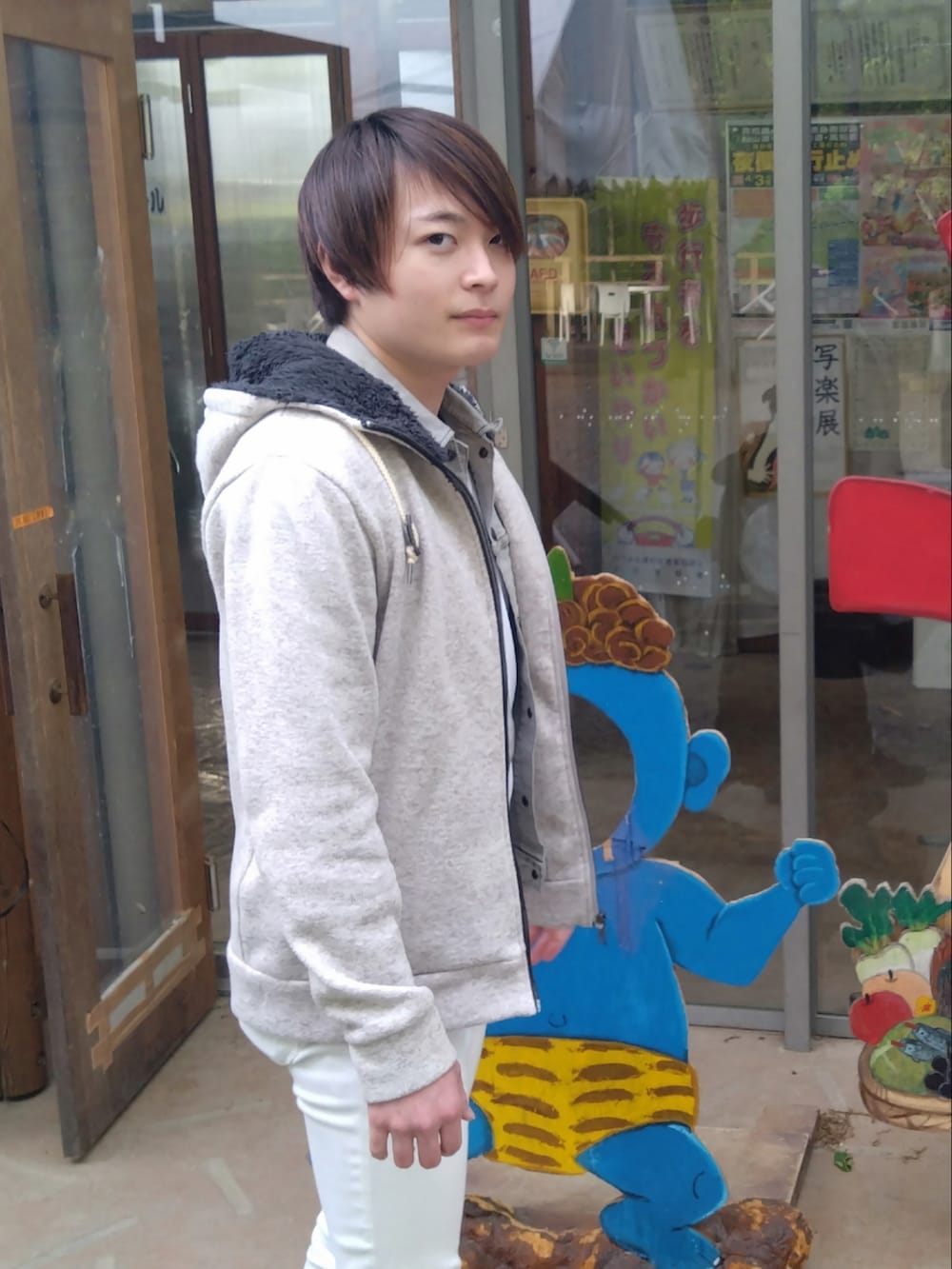 グレー系のデニムジャケット、ホワイト系のタンクトップ、グレー系のパーカーを着用したメンズの春コーディネートの2枚目の写真