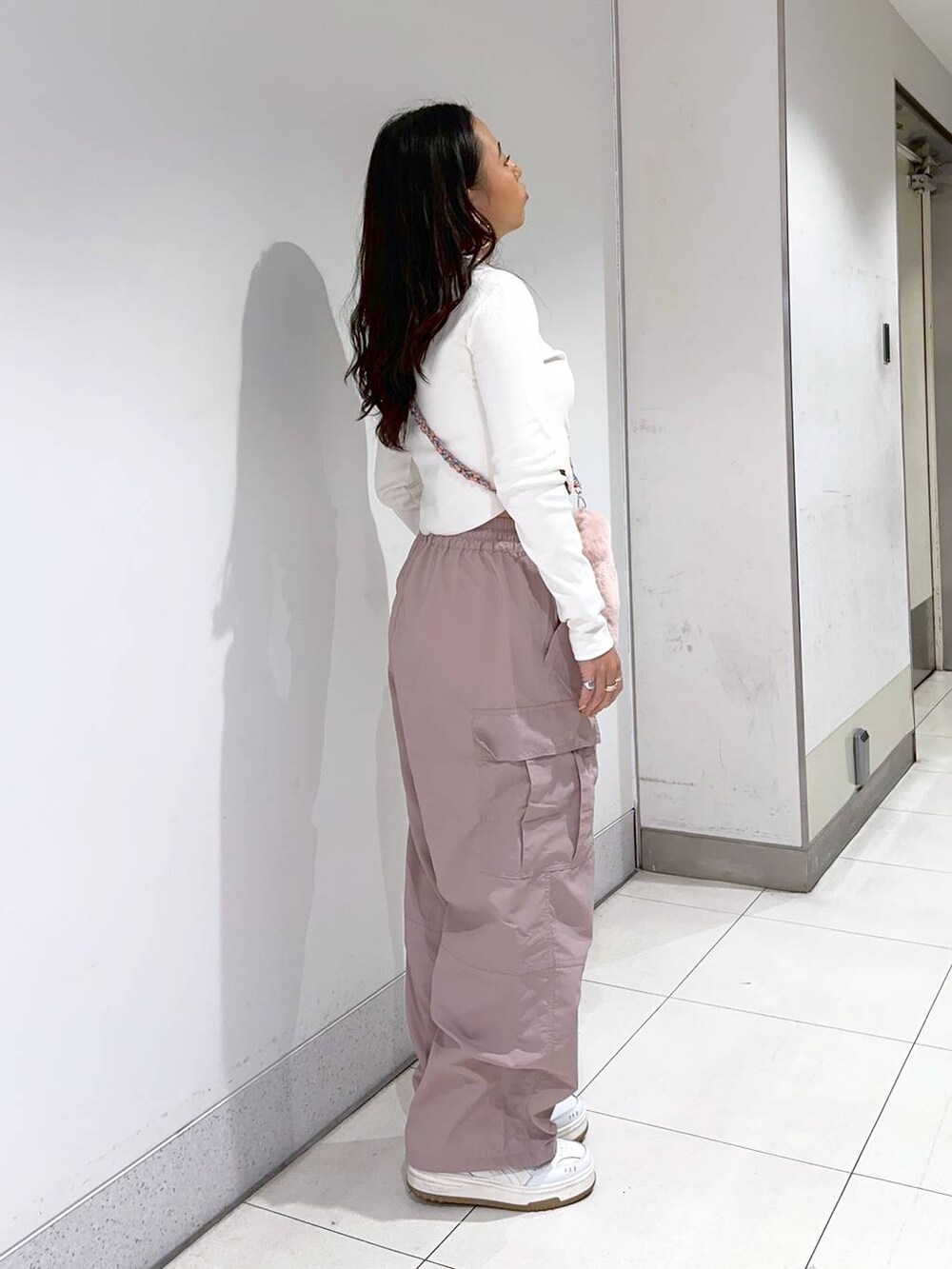 ホワイト系のTシャツ/カットソー、ピンク系のショルダーバッグ、ピンク系のカーゴパンツを着用したレディースの冬コーディネートの3枚目の写真