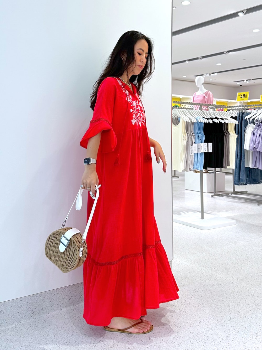 シルバー系のショルダーバッグ、レッド系のワンピースを着用したレディースの夏コーディネートの2枚目の写真