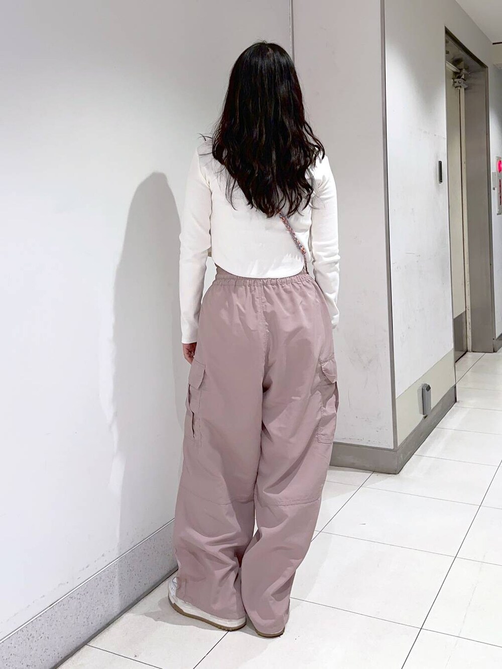 ホワイト系のTシャツ/カットソー、ピンク系のショルダーバッグ、ピンク系のカーゴパンツを着用したレディースの冬コーディネートの2枚目の写真