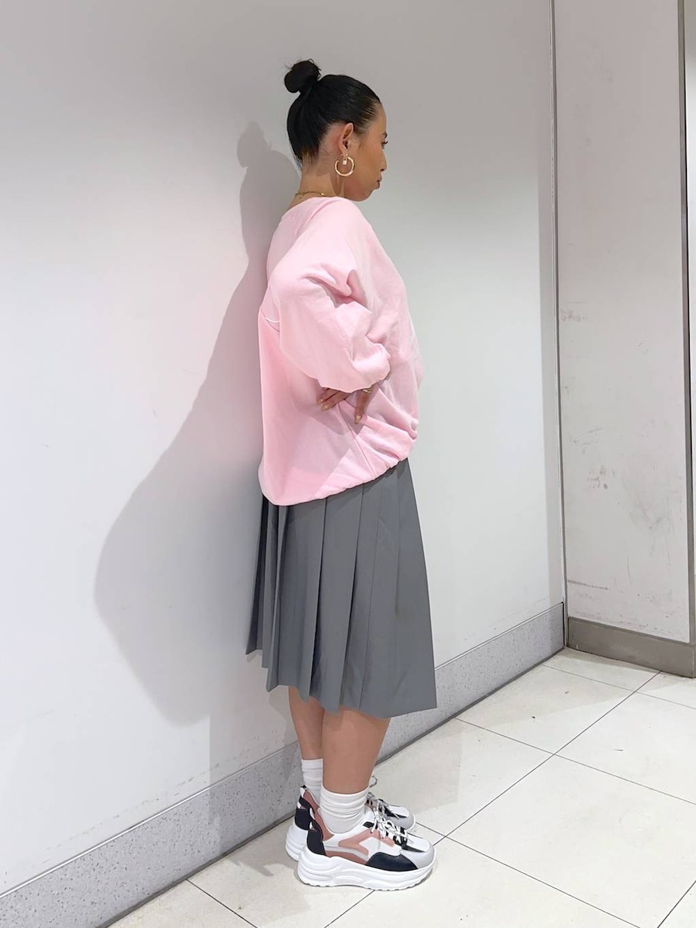 ピンク系のスウェット、グレー系のスカート、ピンク系のスニーカーを着用したレディースの春コーディネートの3枚目の写真
