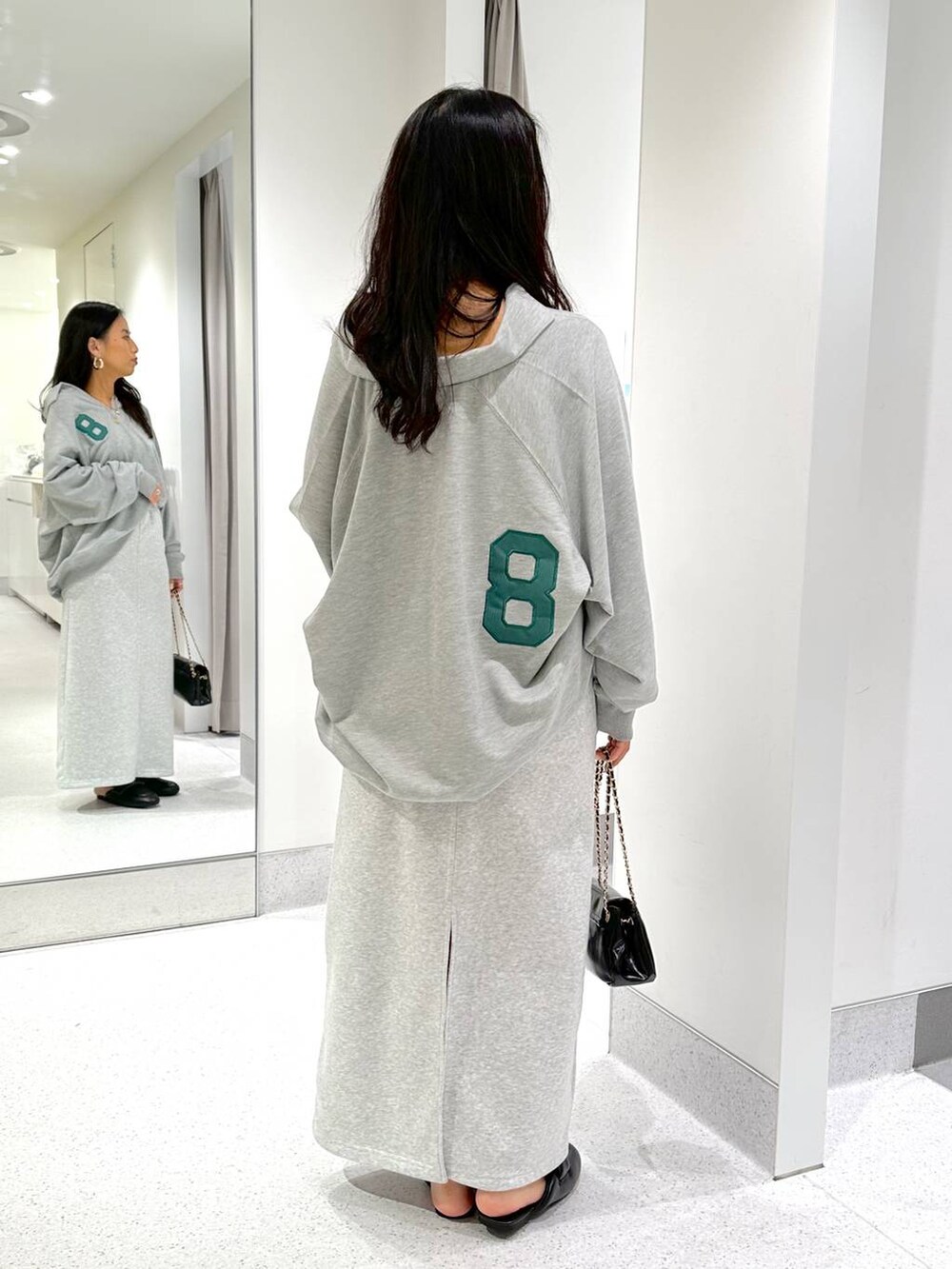 グレー系のスウェット、ブラック系のハンドバッグ、グレー系のスカートを着用したレディースの冬コーディネートの4枚目の写真