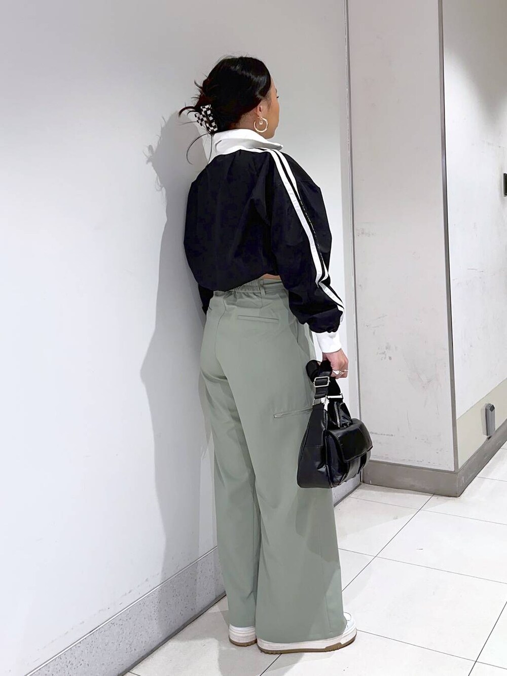 ブラック系のショルダーバッグ、グリーン系のその他パンツ、ブラック系のブルゾンを着用したレディースの冬コーディネートの2枚目の写真