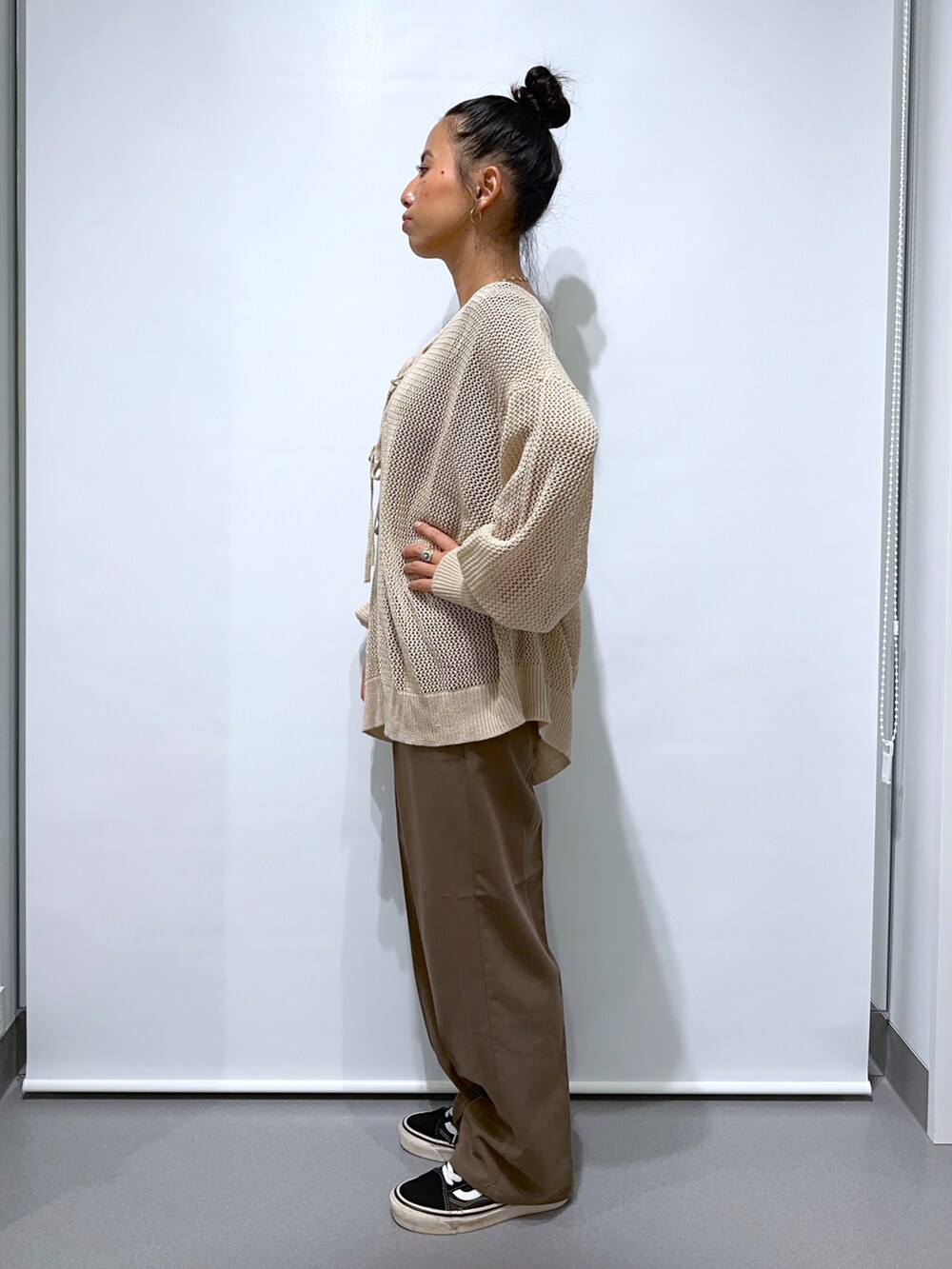 ブラック系のスニーカー、ブラウン系のスラックス、ブラウン系のTシャツ/カットソーを着用したレディースの夏コーディネートの2枚目の写真