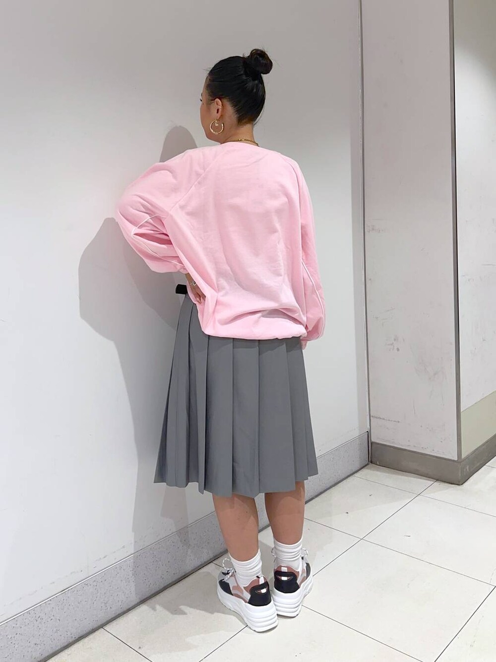 ピンク系のスウェット、グレー系のスカート、ピンク系のスニーカーを着用したレディースの春コーディネートの4枚目の写真