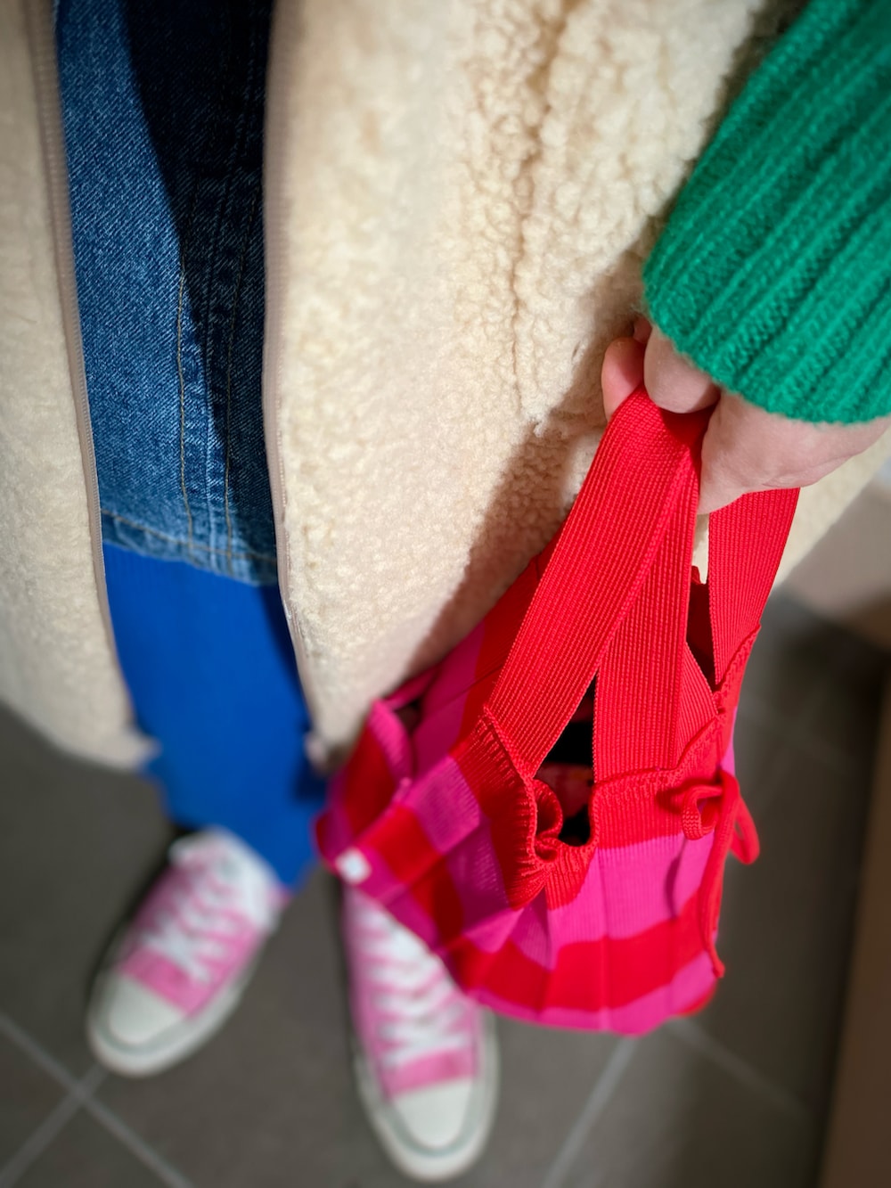 グリーン系のニット/セーター、ブルー系のベスト、ブルー系のスカートを着用したレディースの冬コーディネートの3枚目の写真