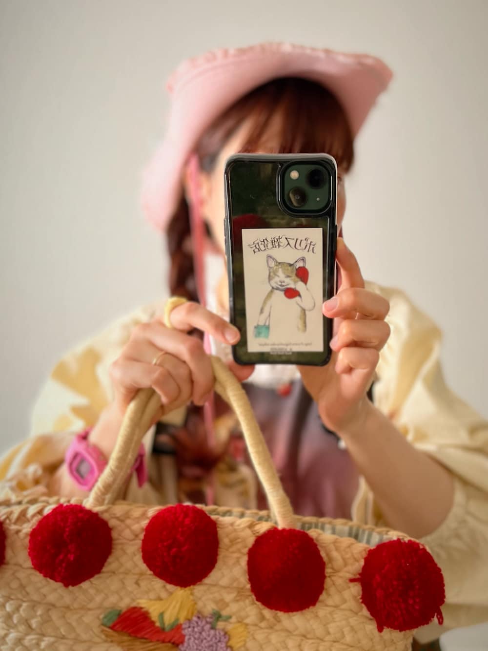 イエロー系のカーディガン/ボレロ、ベージュ系のかごバッグ、グリーン系のスニーカーを着用したレディースの春コーディネートの2枚目の写真