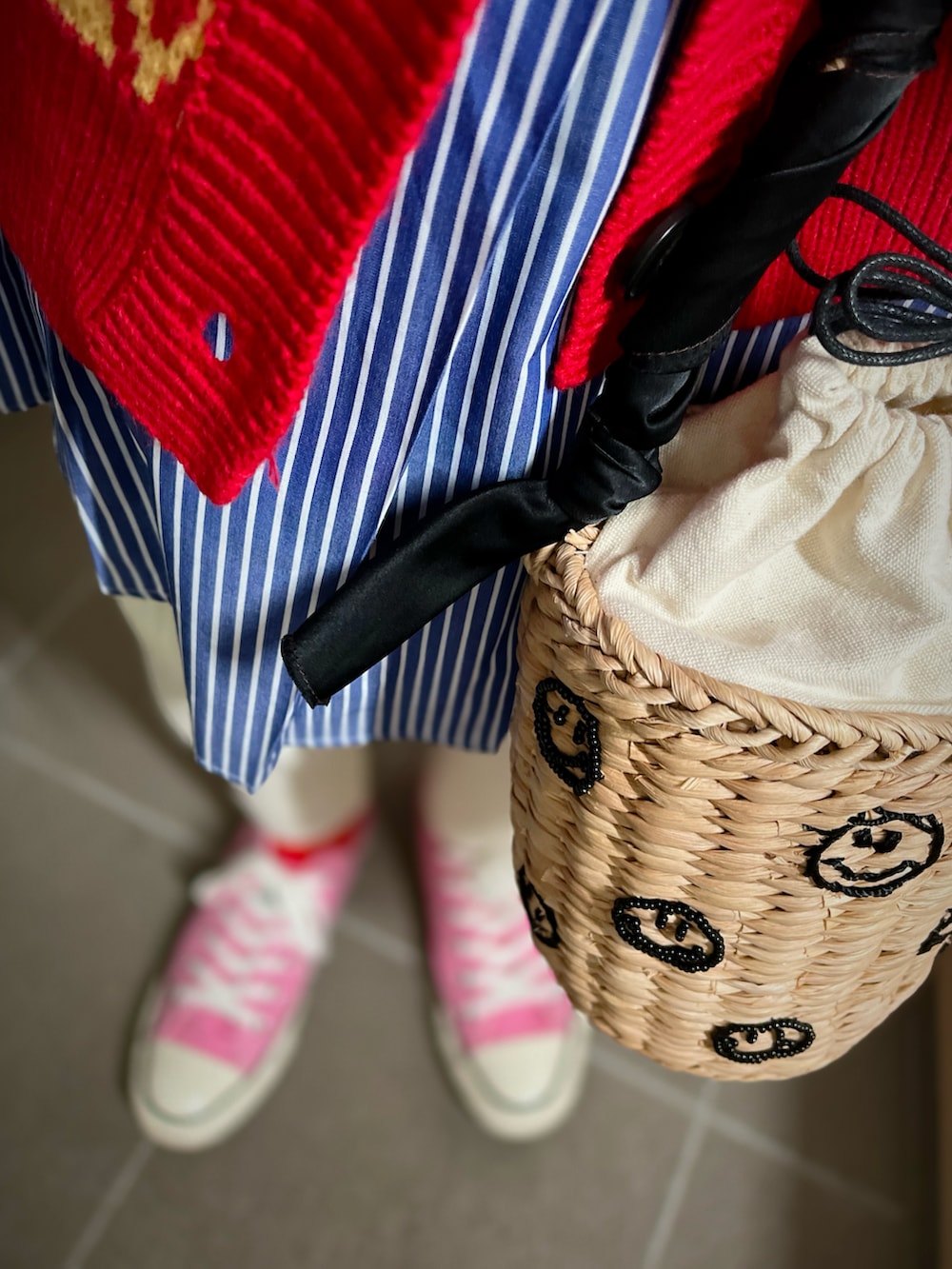 レッド系のカーディガン/ボレロ、ホワイト系のその他パンツ、ピンク系のスニーカーを着用したレディースの冬コーディネートの2枚目の写真