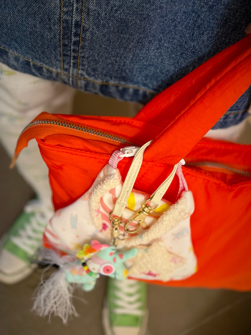 ベージュ系のカーディガン/ボレロ、ブルー系のベスト、グリーン系のスニーカーを着用したレディースの冬コーディネートの2枚目の写真