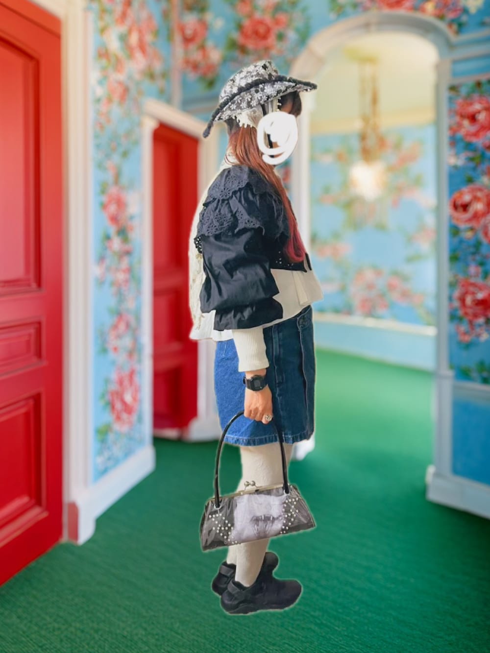 ブラック系のハンドバッグ、ブラック系のカーディガン/ボレロ、ブラック系のスニーカーを着用したレディースの春コーディネートの2枚目の写真