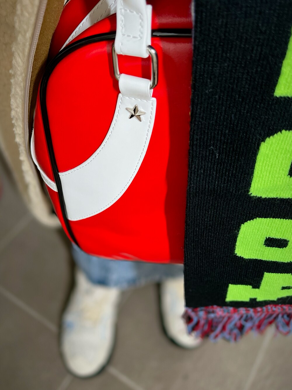 グリーン系のスウェット、レッド系のボストンバッグ、ベージュ系のその他アウターを着用したレディースの冬コーディネートの3枚目の写真