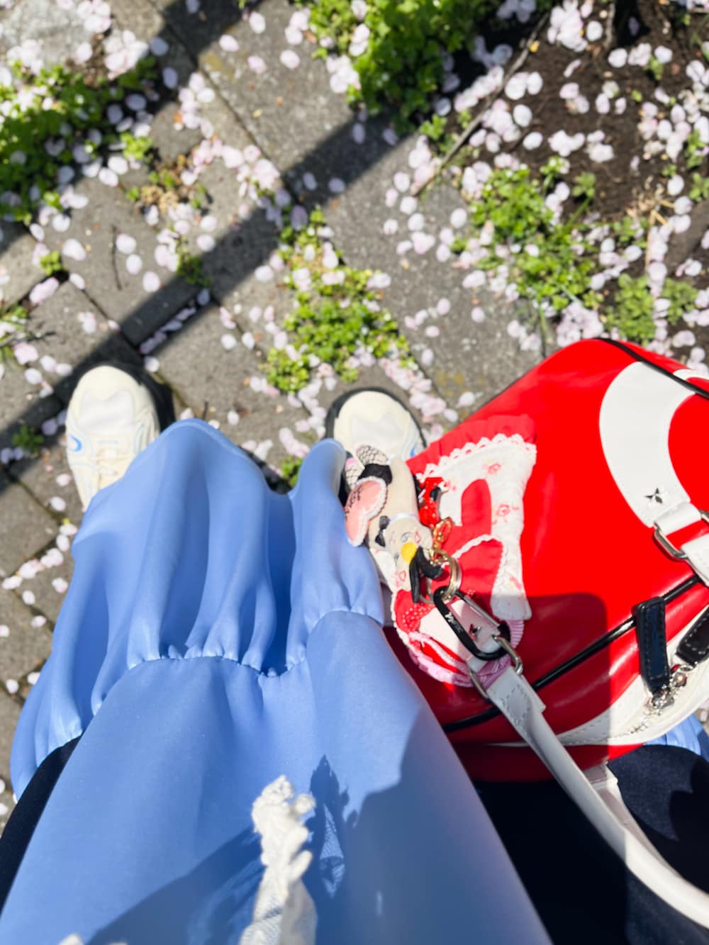 ブルー系のワンピース、レッド系のボストンバッグ、ホワイト系のスニーカーを着用したレディースの春コーディネートの3枚目の写真