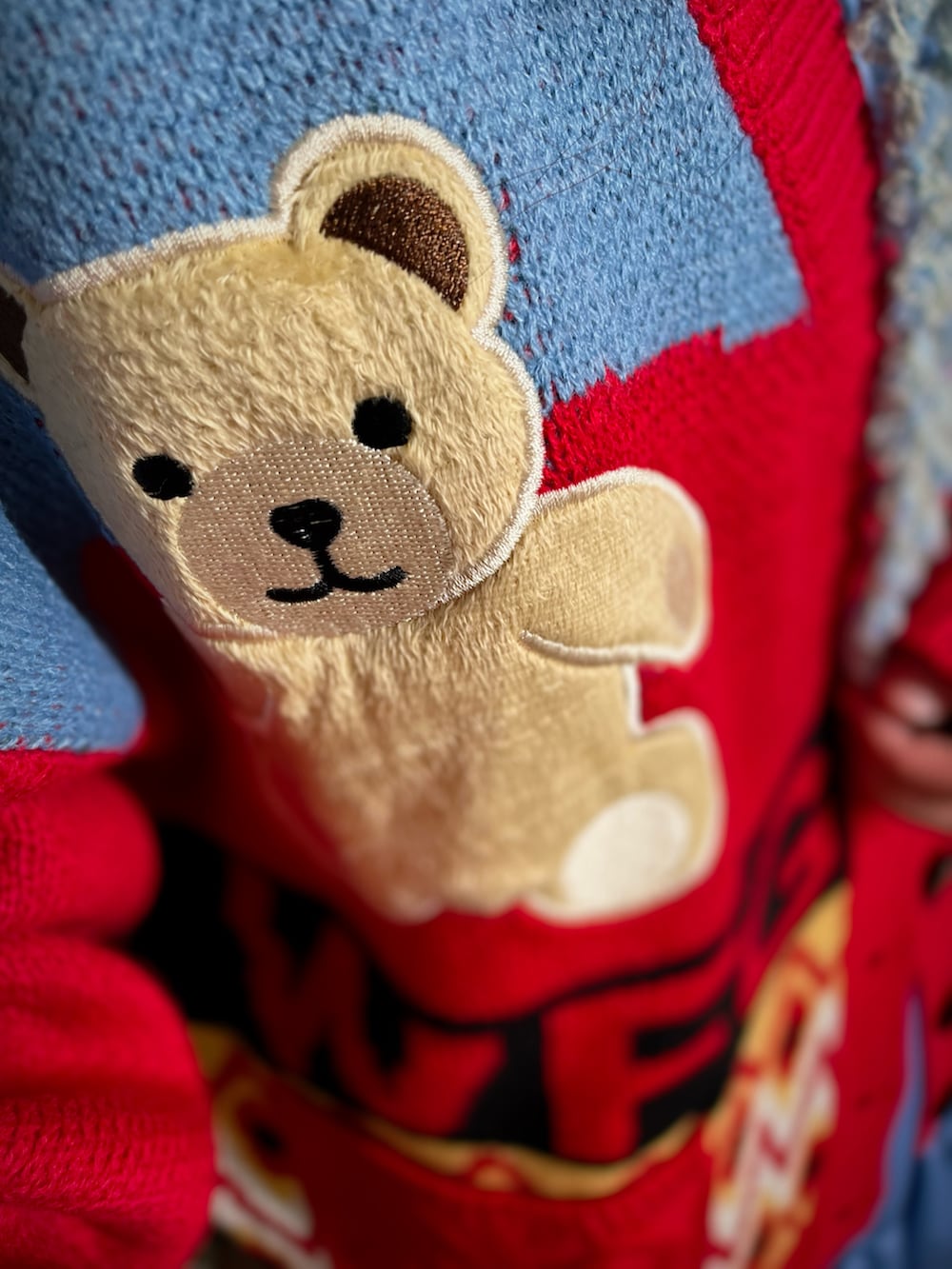 レッド系のカーディガン/ボレロ、ブルー系のワンピース、ホワイト系のスニーカーを着用したレディースの冬コーディネートの2枚目の写真