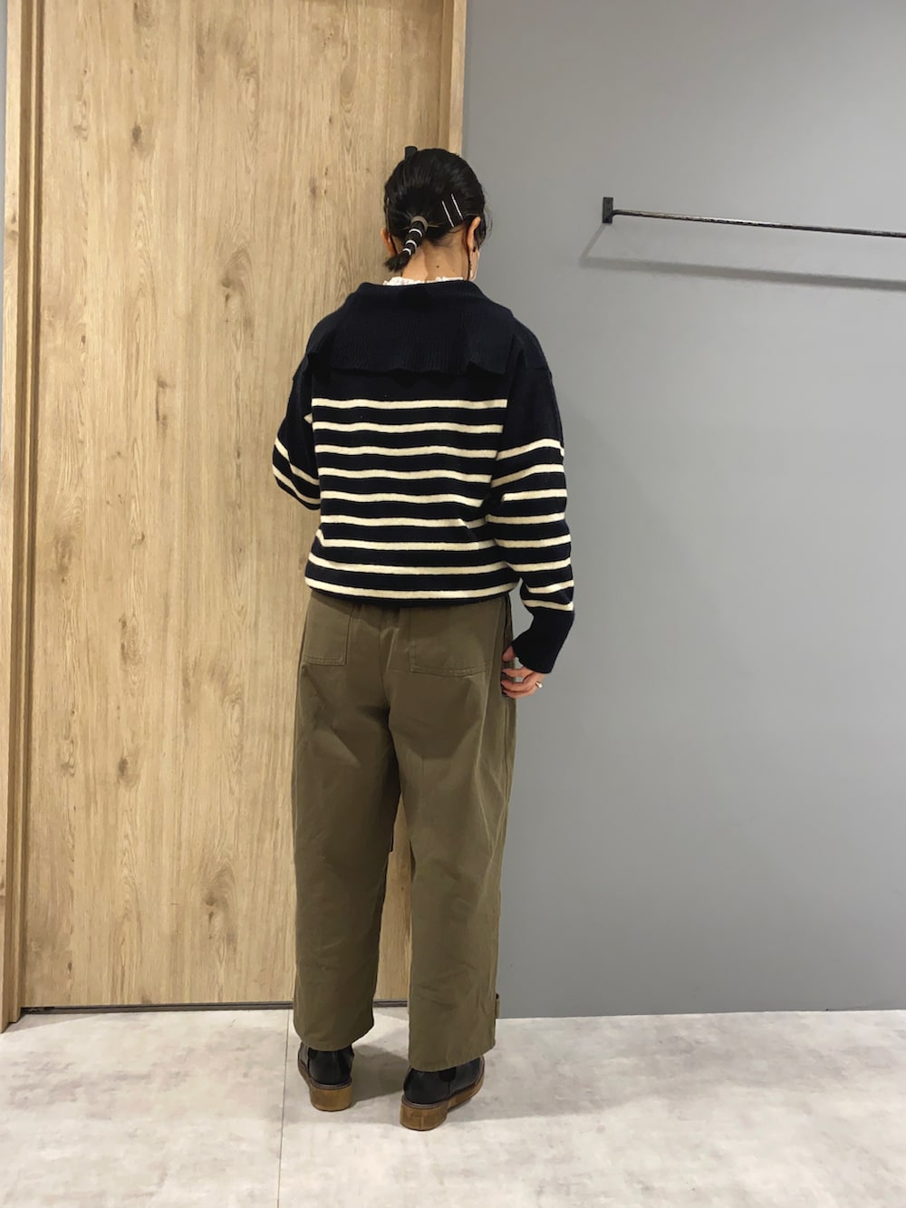 ホワイト系のシャツ/ブラウス、ブラック系のニット/セーター、グリーン系のパンツを着用したレディースの秋コーディネートの3枚目の写真