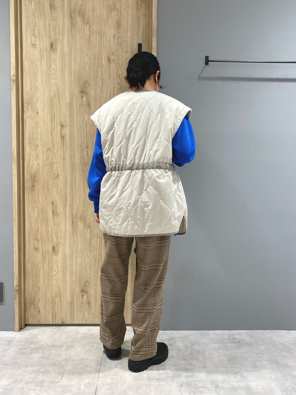 ブルー系のスウェット、ホワイト系のジャケット/アウター、ブラウン系のパンツを着用したレディースの冬コーディネートの3枚目の写真