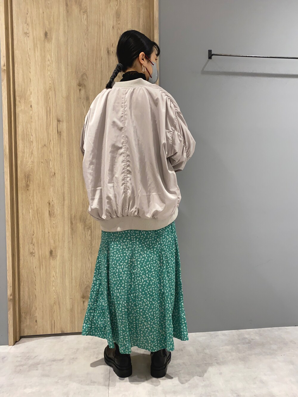 グレー系のスウェット、グレー系のブルゾン、グリーン系のスカートを着用したレディースの春コーディネートの3枚目の写真