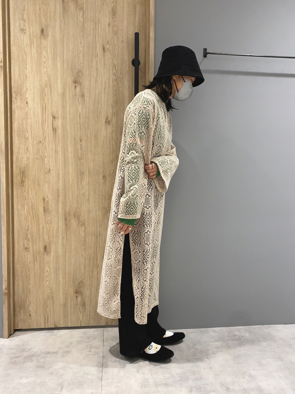 ベージュ系のワンピース、グリーン系のニット/セーター、ブラック系のシューズを着用したレディースの春コーディネートの3枚目の写真