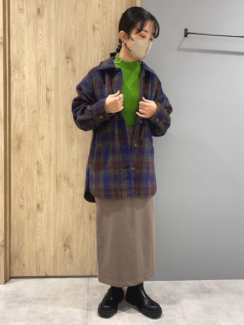 グリーン系のニット/セーター、ブルー系のジャケット/アウター、ベージュ系のスカートを着用したレディースの秋コーディネートの2枚目の写真