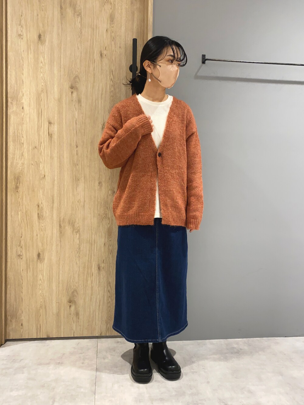 ブルー系のデニムスカート、ホワイト系のジャケット/アウター、オレンジ系のカーディガン/ボレロを着用したレディースの秋コーディネートの4枚目の写真