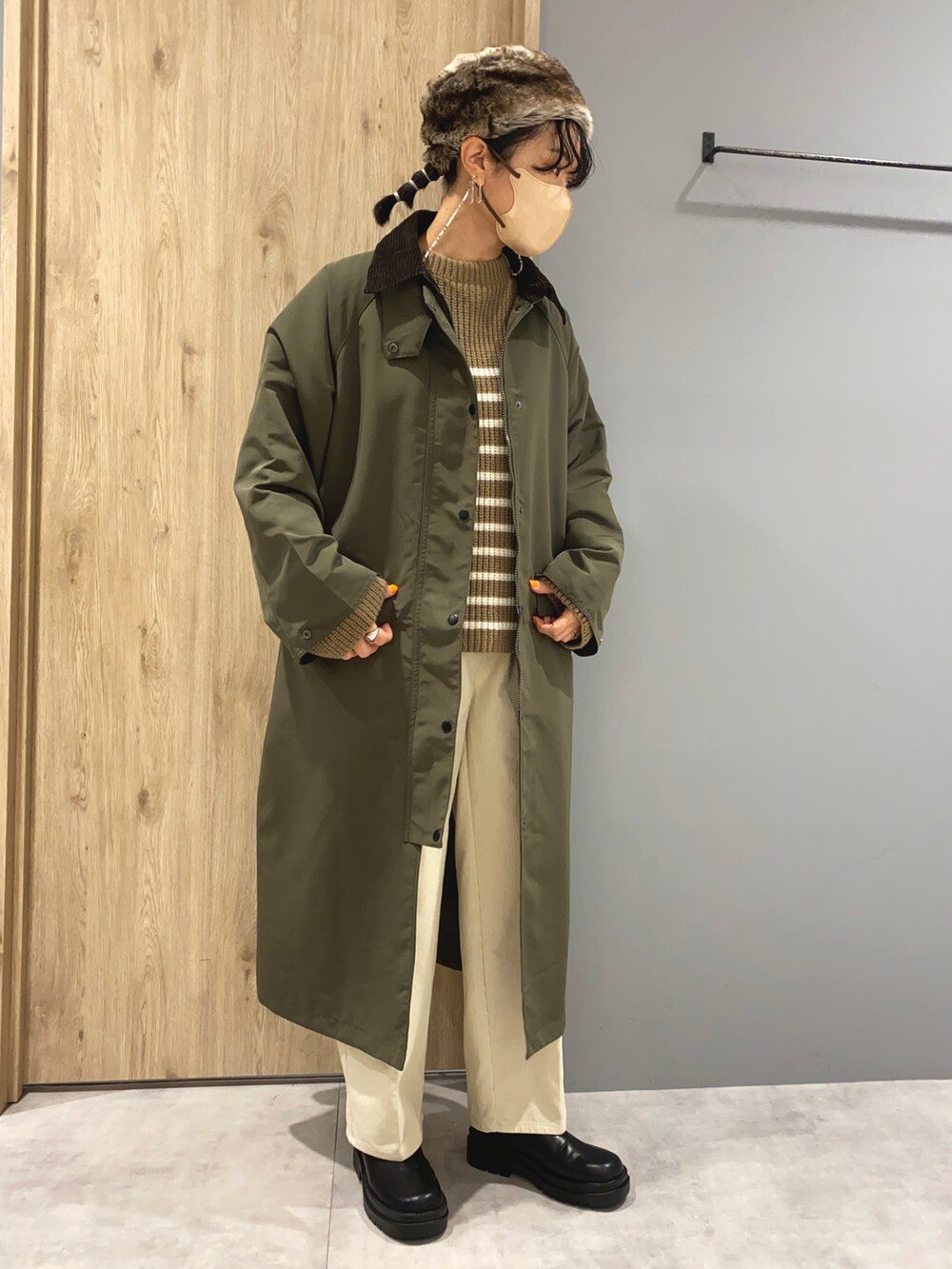 ベージュ系のニット/セーター、グリーン系のジャケット/アウター、ブラック系のブーツを着用したレディースの秋コーディネートの2枚目の写真